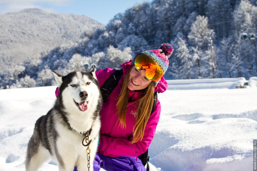 Девушка с собакой зимой в горах